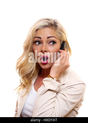 Eine Frau hat einen überraschten Blick auf ihrem Gesicht während des Gesprächs auf dem Handy. Stockfoto