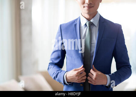 Junge chinesische Geschäftsmann Ankleiden am Morgen Stockfoto