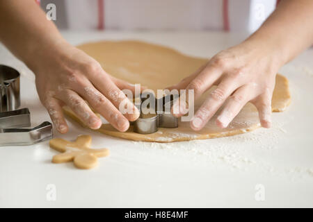 Nahaufnahme eines professionellen Konditor Hände schneiden gingermen Stockfoto