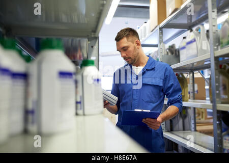 Kfz-Mechaniker mit Öl und Zwischenablage bei Car shop Stockfoto