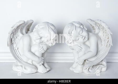 Statuen von Amoretten schlafen auf weißem Hintergrund. Stockfoto