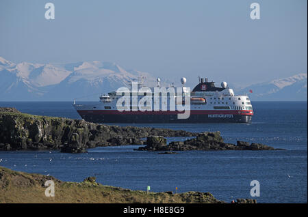 Arktische Kreuzfahrtschiff M V Fram, mit Schnee bedeckt Berge des Festlandes hinaus aus der Insel Grimsey, N.E. Island vor Anker. Stockfoto