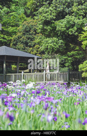 Junge Japanerin auf Holzterrasse in einem Stadtpark Stockfoto