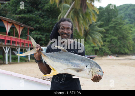 Ein Mann hält einen frisch gefangenen Makrelen Fisch in Castara in Tobago, Trinidad und Tobago, West Indies, Karibik, Mittelamerika Stockfoto