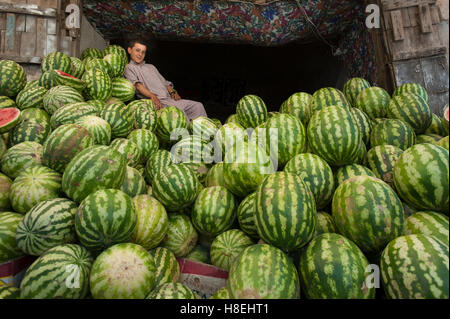 Ein Junge in einem Markt ruht auf einem riesigen Haufen Wasser Melonen, Herat, Afghanistan, Asien Stockfoto