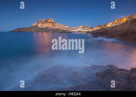 Wellen umrahmen das Dorf thront auf Vorgebirge in der Abenddämmerung, Castelsardo, Golf von Asinara, Provinz Sassari, Sardinien, Italien Stockfoto