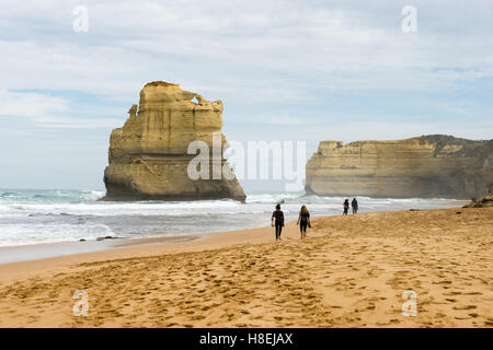 Menschen gehen an einem Strand mit einem der zwölf Apostel geologische Formation im Hintergrund, Victoria, Australien, Pazifik Stockfoto