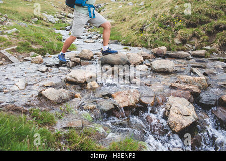 Mann im trekking Stiefel Wandern outdoor mit Fluss und Steinen auf Hintergrund. Lifestyle-Reisen-überleben-Konzept Stockfoto