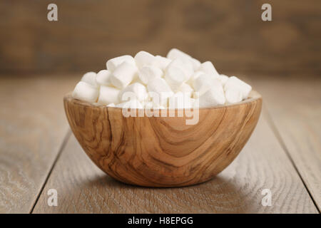 weiße Marshmallows in Holzschale auf Tisch Stockfoto