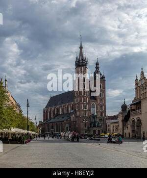 Blick auf den Main Square von Krakau mit der Kirche St. Mary und Pferde und Kutschen in der Ferne. Stockfoto