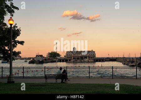 Paar sitzen Sonnenuntergang Chicago Seeverkehrssicherheit Station / Mole Zugang / Marine Pier / Hafen Dusable Stockfoto