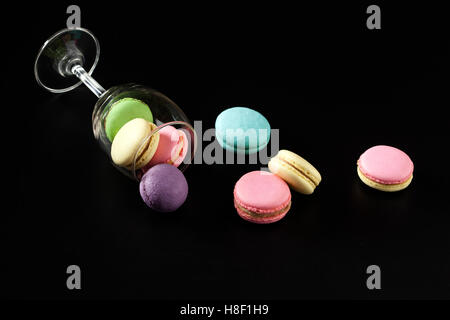 Verschiedene bunte französische Macarons auf schwarzem Hintergrund Stockfoto