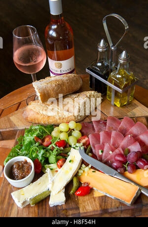 Käse, Schinken, Trauben und Brot serviert auf einem hölzernen platter.a UK "Pflüger Lunch" der Pflüger Stockfoto