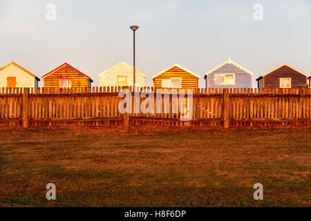 Reihe von bunten Strandhäuschen bei Sonnenuntergang in Southwold, Suffolk, UK Stockfoto