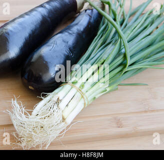 Aubergine mit Frühlingszwiebeln auf Schneidebrett Stockfoto
