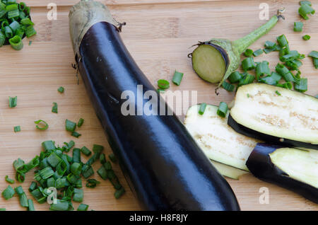Aubergine mit Frühlingszwiebeln auf Schneidebrett Stockfoto