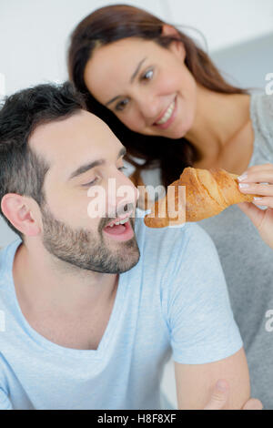 Romantisch zu zweit teilen eine croissant Stockfoto
