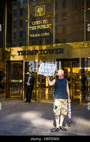 NEW YORK CITY - 3. September 2016: Demonstrant Donald Trump Maske steht am Eingang zum Trump Tower mit einem Schild tragen. Stockfoto