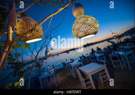 Informelle am Strand sitzen mit dekorativer Kürbis-Leuchten hängen von einem Baum in Bodrum, Türkei Stockfoto