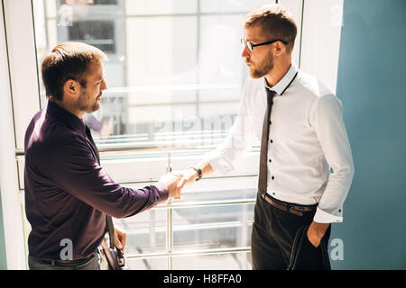 Handshake Geschäftspartner trafen sich auf der Treppe im Bürogebäude Stockfoto