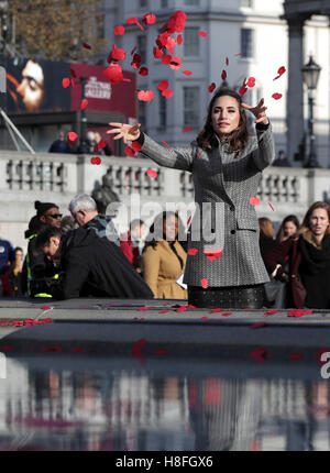 Hinweis alternative Ernte Laura Wright wirft Mohnblumen in den Brunnen während einer Veranstaltung auf dem Londoner Trafalgar Square, Tag des Waffenstillstands zu markieren. Stockfoto