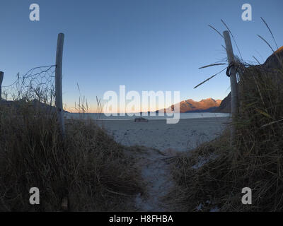 kleine Spur und Tor vor weißen Sandstrand mit Meer- und Bergblick Hintergrund Stockfoto