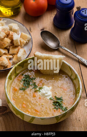 rote Linsensuppe in Schüssel auf rustikale Tischdekoration Stockfoto