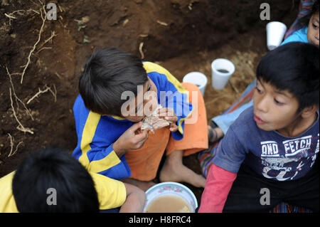 Maya indigene Kinder essen Mittagessen zur Verfügung gestellt von lokalen NPO in Aqua Escondida in Solola Abteilung, Guatemala. Stockfoto