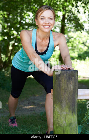 Reife Frau Aufwärmen vor dem Training In Landschaft Stockfoto