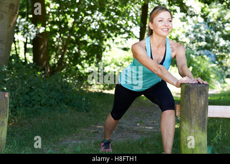 Reife Frau Aufwärmen vor dem Training In Landschaft Stockfoto