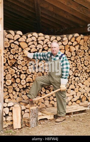 Senior Mann stand neben seinem Holzstapel Stockfoto