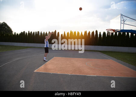 Ein Mann, groß, vorbereiten, einen Basketball, in einem Park zu schießen Stockfoto