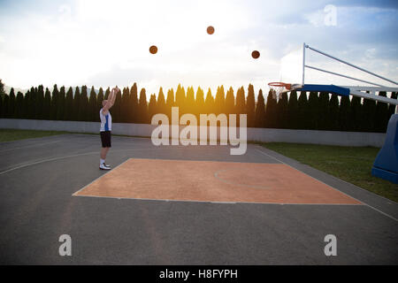 Ein Mann, groß, vorbereiten, einen Basketball, in einem Park zu schießen Stockfoto