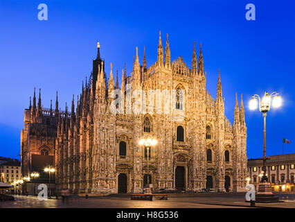 beleuchtete Fassade, Dekorationselemente und goldene Heilige Statue ganz oben auf der Turmspitze des Mailänder gotischen Dom in Mailand, Italien. Stockfoto