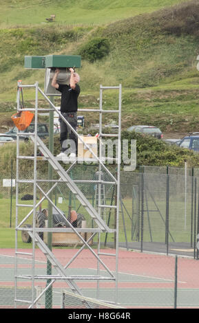 Kaukasische Mann mit einem Gerüst Turm mit der Arbeit an einer Reihe von Fluter, Großbritannien Stockfoto