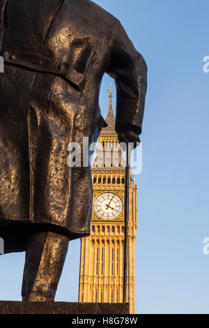 Die Statue von Winston Churchill in Parliament Square. Die Elizabeth-Turm die Häuser Big Ben kann in gesehen worden Hintergrund. Stockfoto