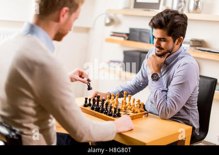 Zwei junge Männer spielen Schach im Zimmer Stockfoto