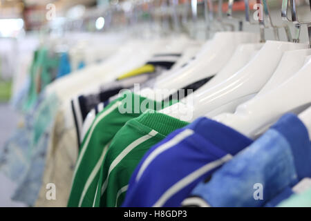 Kleidung hängen auf einem Regal in einem Kaufhaus. Stockfoto