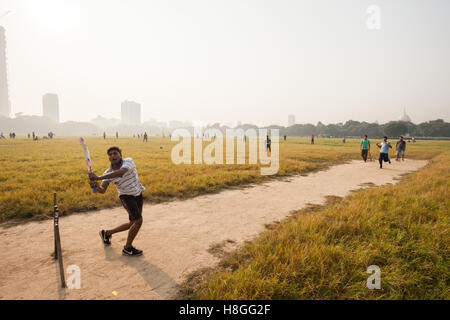 Junge Männer spielen Cricket auf dem Maidan in Kolkata (Kalkutta), Indien Stockfoto