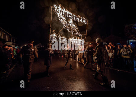 East Hoathly, UK. 12. November 2016. East Hoathly & Halland Karneval - Lagerfeuer für Erinnerung Parade. Jedes Jahr Tausende von Zuschauer strömen in East Sussex-Dorf in der Nähe von Lewes, die Prozession der Bazing Feuer Banner auf die Lagerfeuer-Website zu sehen. Sie führen auch Mohn, die jeweils darstellt und erinnert sich an einen Dorfbewohner, die in den beiden Weltkriegen verloren. Bildnachweis: Jim Holden/Alamy Live-Nachrichten Stockfoto