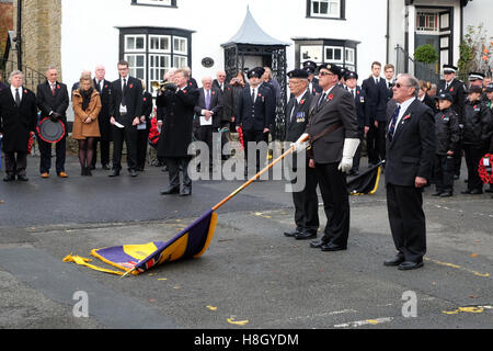 Kington, Herefordshire, England 13. November 2016. Die Royal British Legion Flagge wird gesenkt, da der letzte Beitrag auf der Trompete am Kriegerdenkmal in Kington Herefordshire am Remembrance Day Sonntag gespielt wird. Stockfoto