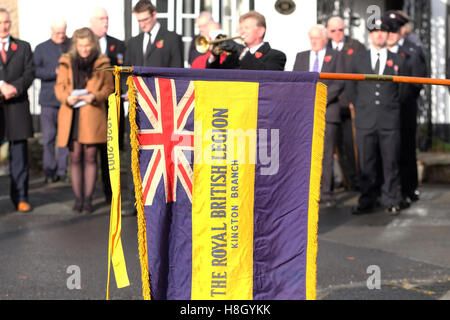 Kington, Herefordshire, England 13. November 2016. Die Royal British Legion Flagge wird gesenkt, da der letzte Beitrag auf der Trompete am Kriegerdenkmal in Kington Herefordshire am Remembrance Day Sonntag gespielt wird. Foto-Steven Mai / Alamy Live News Stockfoto