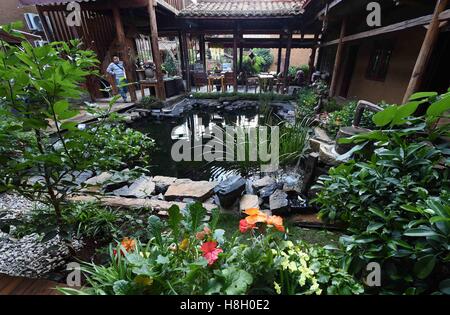 (161113)--QIUBEI, 13. November 2016 (Xinhua)--ein Besucher blickt auf den Innenhof in einer Taverne in Xianrendong Dorf Qiubei County, Südwesten der chinesischen Provinz Yunnan, 12. November 2016. Das jährliche pro-Kopf-Einkommen des Dorfes stieg von 300 bis 30.000 Yuan in den letzten 20 Jahren durch die Entwicklung der Tourismusindustrie. (Xinhua/Yang Zongyou) (Zyd) Stockfoto