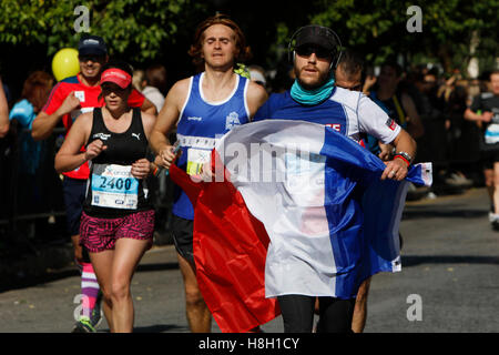 Athen, Griechenland. 13. November 2016. Ein Läufer trägt eine französische Flagge. Tausende von Menschen aus der ganzen Welt nahmen an 2016 Athen Marathon authentisch, die in der Stadt von Marathon beginnt und endet in Athen, die Route, die der Legende nach zuerst von den griechischen Boten Pheidippides 490 v. Chr. betrieben wurde. Stockfoto