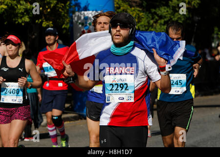 Athen, Griechenland. 13. November 2016. Ein Läufer ist eingehüllt in eine französische Flagge. Tausende von Menschen aus der ganzen Welt nahmen an 2016 Athen Marathon authentisch, die in der Stadt von Marathon beginnt und endet in Athen, die Route, die der Legende nach zuerst von den griechischen Boten Pheidippides 490 v. Chr. betrieben wurde. Stockfoto