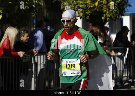 Athen, Griechenland. 13. November 2016. Ein Läufer ist umhüllt von einer italienischen Flagge. Tausende von Menschen aus der ganzen Welt nahmen an 2016 Athen Marathon authentisch, die in der Stadt von Marathon beginnt und endet in Athen, die Route, die der Legende nach zuerst von den griechischen Boten Pheidippides 490 v. Chr. betrieben wurde. Stockfoto