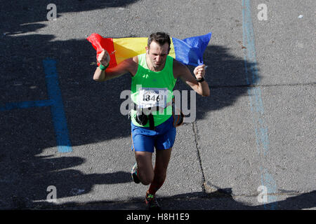 Athen, Griechenland. 13. November 2016. Ein Läufer trägt eine rumänische Fahne. Tausende von Menschen aus der ganzen Welt nahmen an 2016 Athen Marathon authentisch, die in der Stadt von Marathon beginnt und endet in Athen, die Route, die der Legende nach zuerst von den griechischen Boten Pheidippides 490 v. Chr. betrieben wurde. Stockfoto