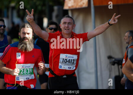 Athen, Griechenland. 13. November 2016. Ein Läufer macht einen Doppelsieg auf die Kamera zu unterzeichnen. Tausende von Menschen aus der ganzen Welt nahmen an 2016 Athen Marathon authentisch, die in der Stadt von Marathon beginnt und endet in Athen, die Route, die der Legende nach zuerst von den griechischen Boten Pheidippides 490 v. Chr. betrieben wurde. Stockfoto