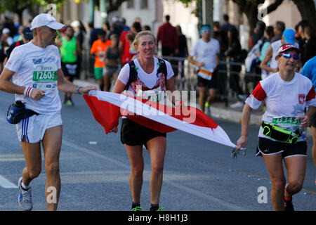 Athen, Griechenland. 13. November 2016. Drei polnische Läufer tragen eine polnische Flagge. Tausende von Menschen aus der ganzen Welt nahmen an 2016 Athen Marathon authentisch, die in der Stadt von Marathon beginnt und endet in Athen, die Route, die der Legende nach zuerst von den griechischen Boten Pheidippides 490 v. Chr. betrieben wurde. Stockfoto