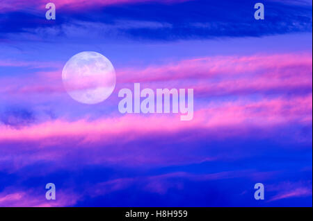 Mond-Clouds ist eine lebendige bunte surreale Wolkengebilde mit dem Vollmond steigt in den Himmel. Stockfoto